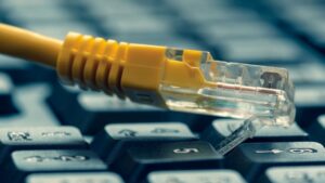 yellow ethernet cable on top of computer keyboard