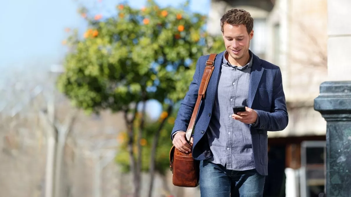 man looking at phone learning the benefits of voip