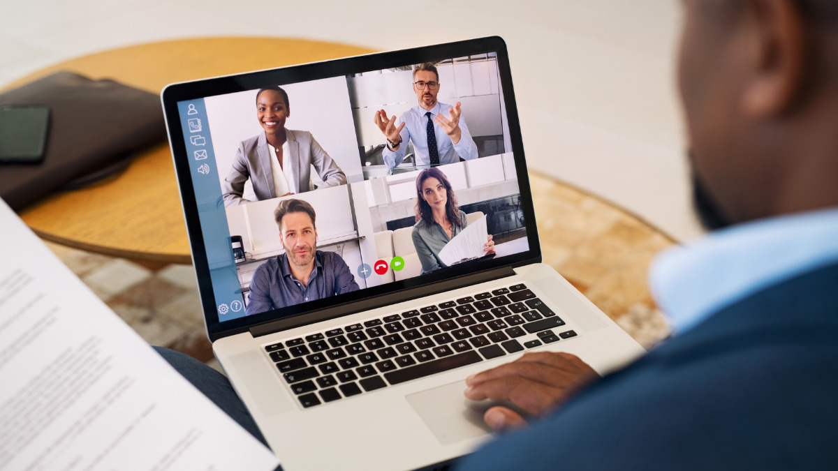man using laptop for business video call with 4 other participants on screen