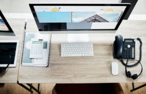desk with computers and telephone on