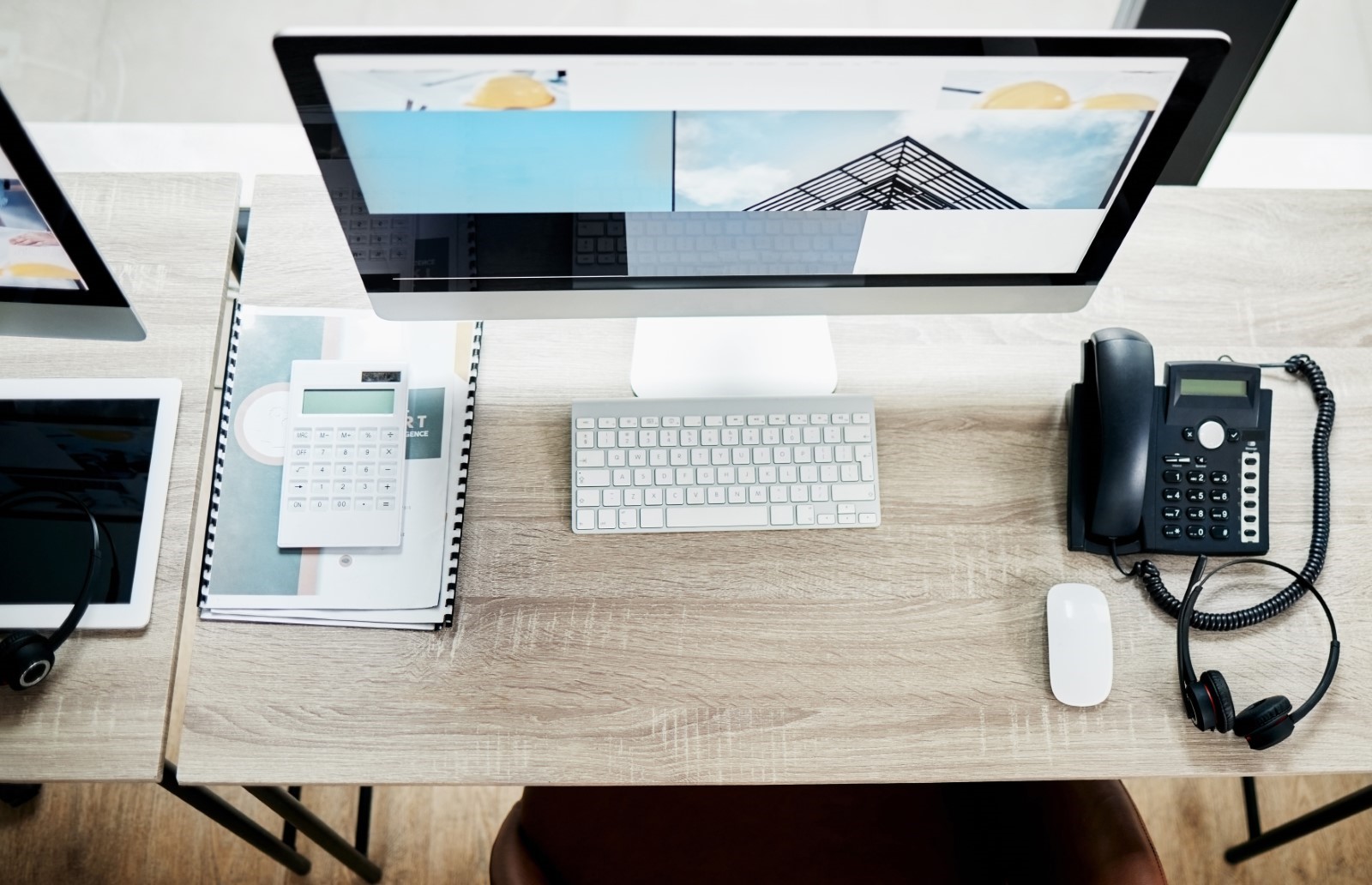 desk with computers and telephone on